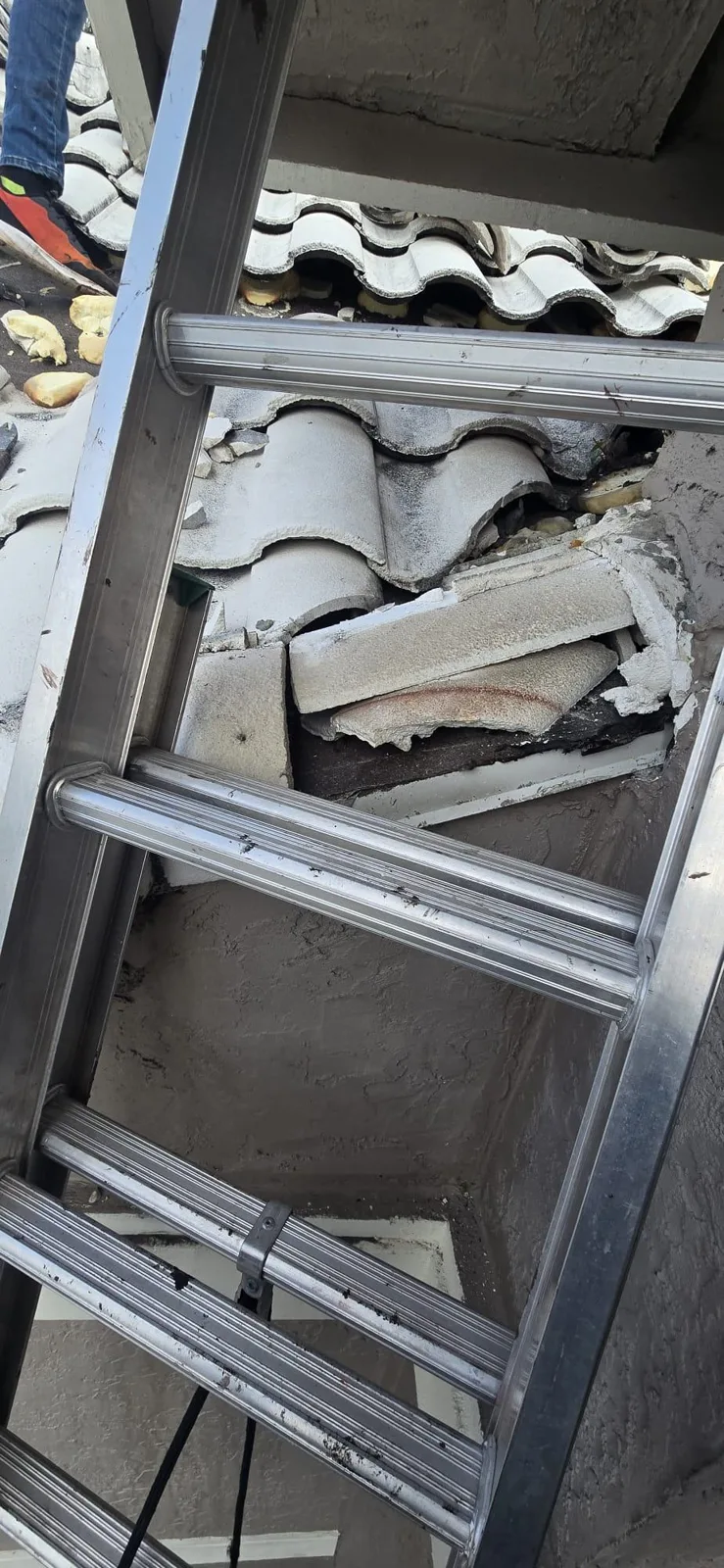 Ladder and removed tiles placed next to the repair area