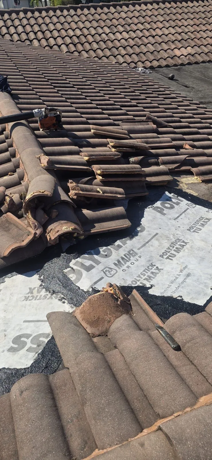 Tiles set aside on the membrane during the roof repair
