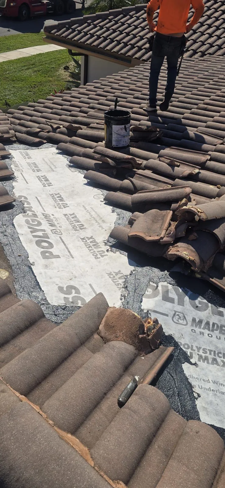 Technician working on the repair of a tile roof